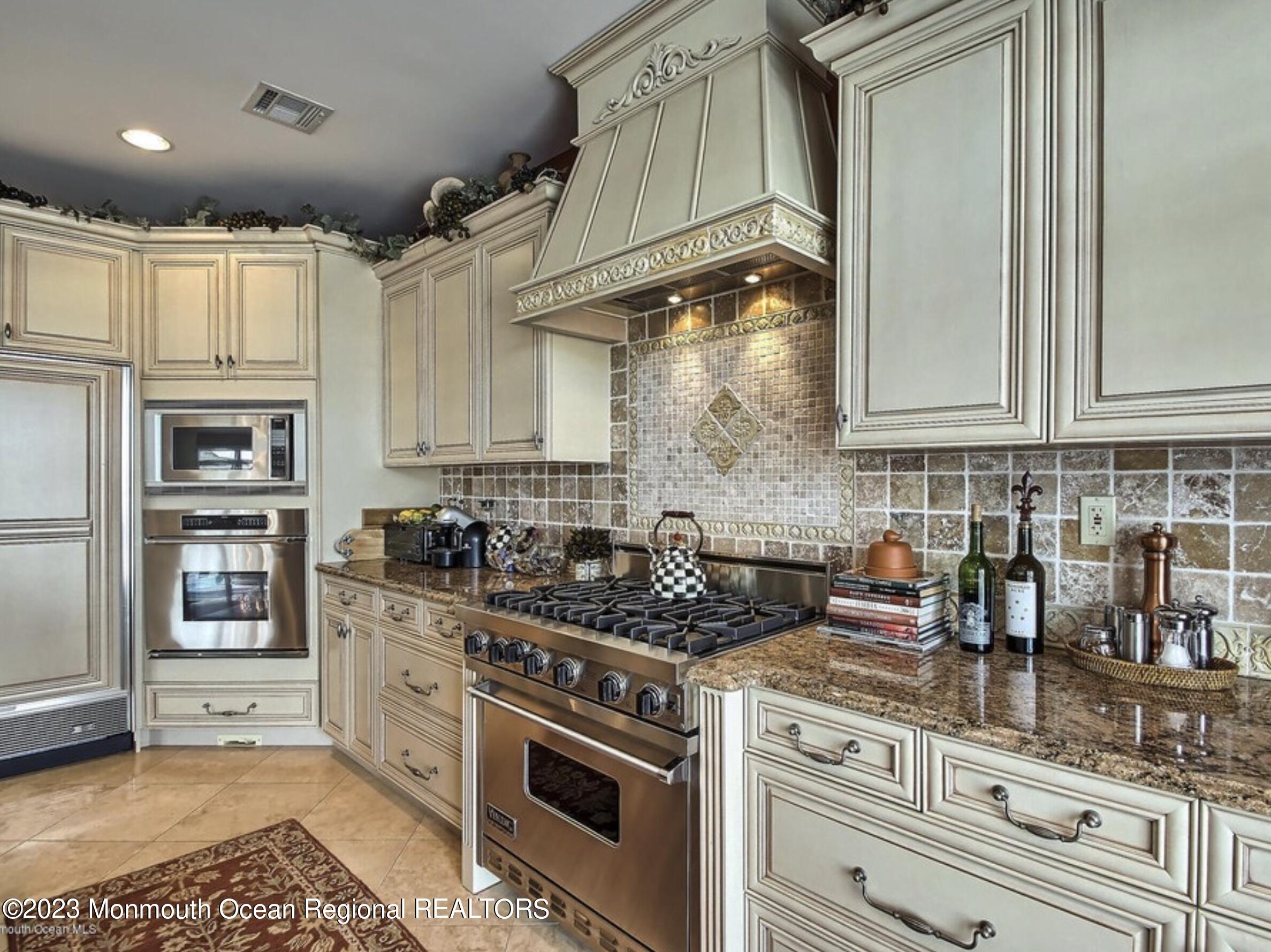220 Pointe Drive Mantoloking, NJ 08738 - Photo 7 of 30 a kitchen with stainless steel appliances granite countertop a stove a sink and white cabinets