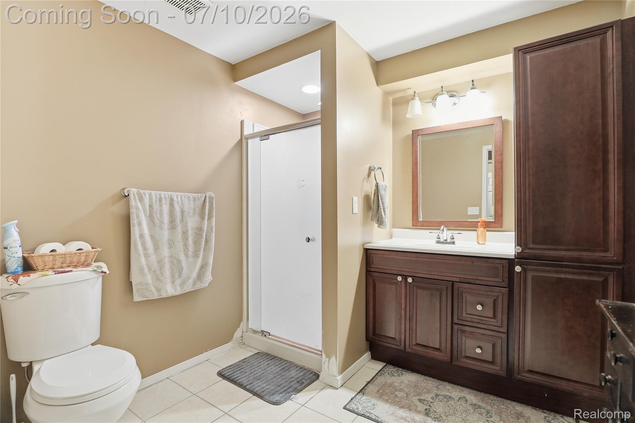 5275 East Maple Avenue Grand Blanc, MI 48439 - Photo 28 of 53 Bathroom featuring a shower with a sliding glass door, a toilet, and a vanity with a white countertop
