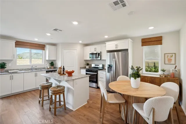 a kitchen with sink refrigerator dining table and chairs