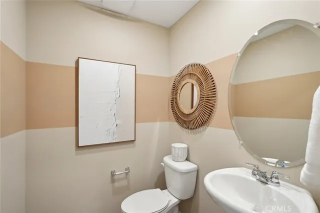 a bathroom with a toilet a sink and a mirror