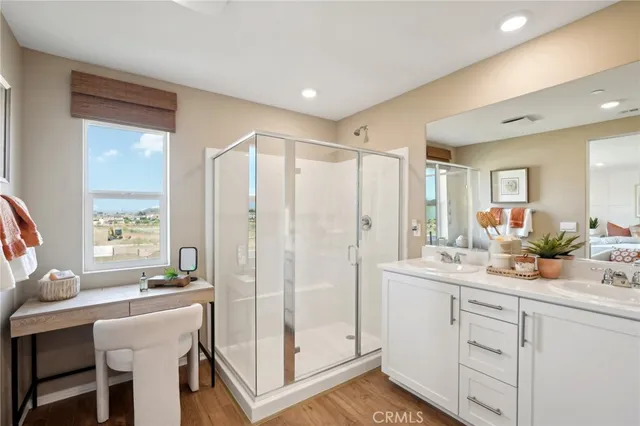 a spacious bathroom with a double vanity sink a mirror a shower and a bathtub