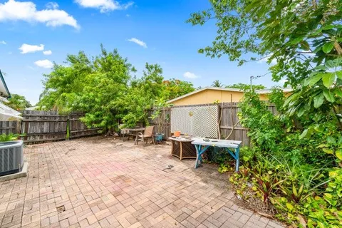 a backyard of a house with table and chairs