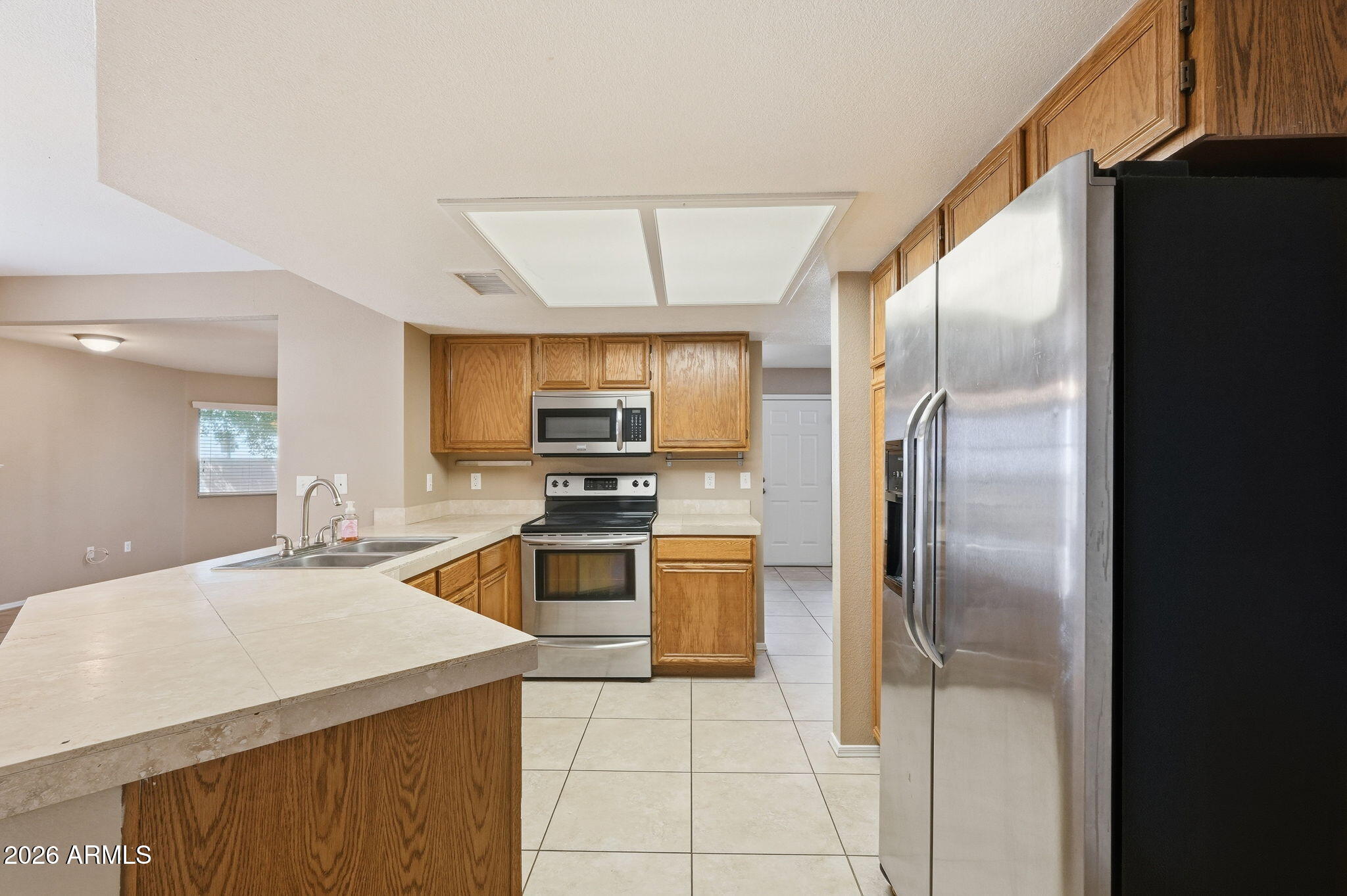 1229 North Alma School Road, Unit 1 Mesa, AZ 85201 - Photo 12 of 38 a kitchen with stainless steel appliances a refrigerator sink and stove