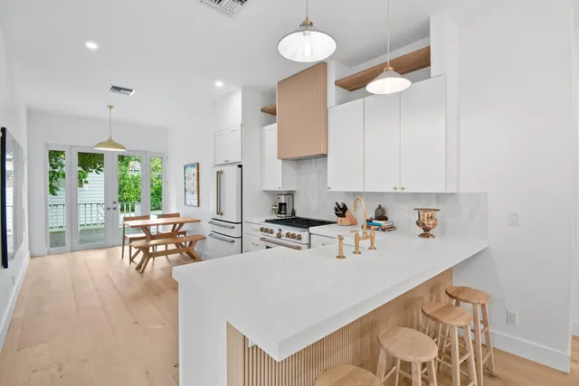 a kitchen with a sink a stove and white cabinets