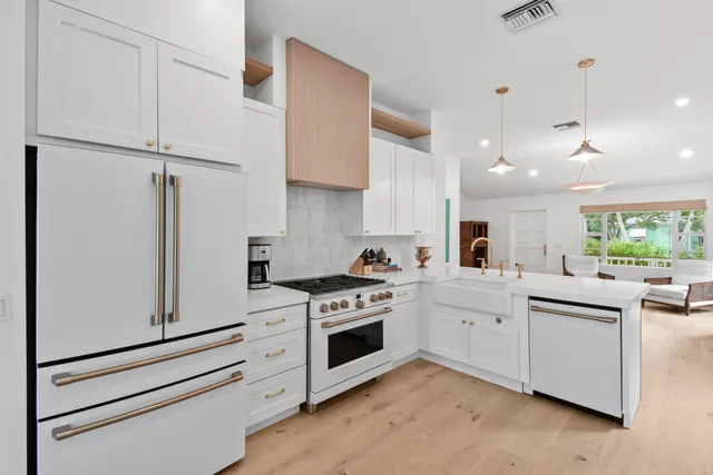 a kitchen with white cabinets and white appliances