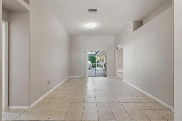 a view of empty room with wooden floor and window