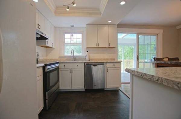 54 Forest Road Salisbury, MA 01952 - Photo 3 of 17 a kitchen with granite countertop white cabinets and white appliances