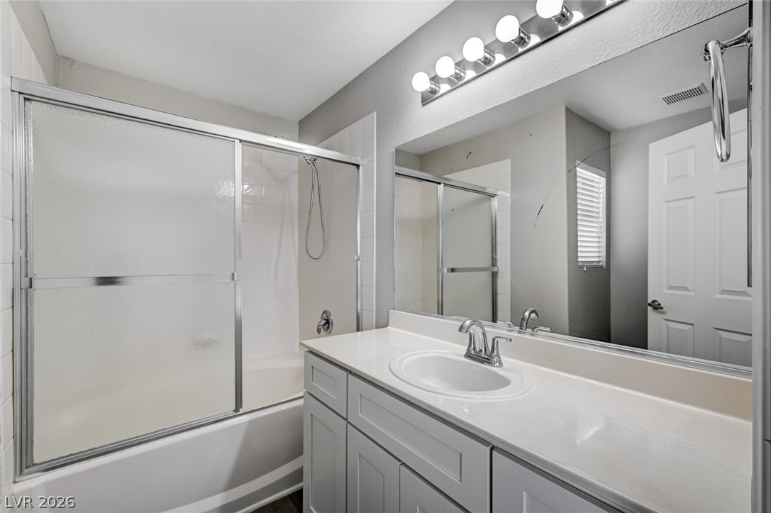 7259 Cestrum Road Las Vegas, NV 89113 - Photo 17 of 35 A well-lit bathroom features a spacious vanity with an integrated sink and an adjacent shower-tub combination.