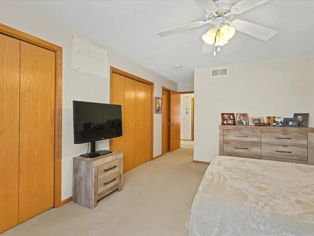a view of a bedroom with cabinet flat screen tv and closet