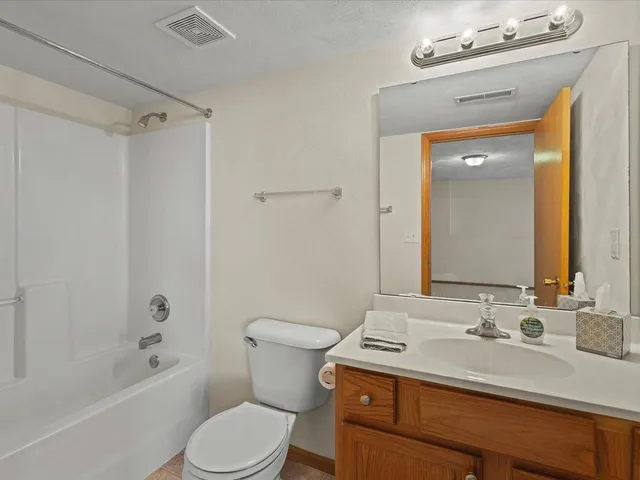 a bathroom with a sink toilet vanity and shower