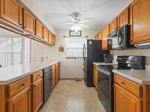 a kitchen with stainless steel appliances granite countertop a refrigerator a stove top oven a sink and dishwasher