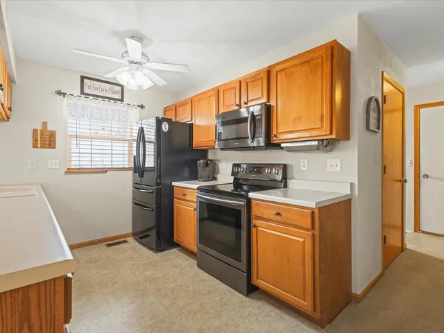 a kitchen with stainless steel appliances granite countertop a stove a sink and a refrigerator