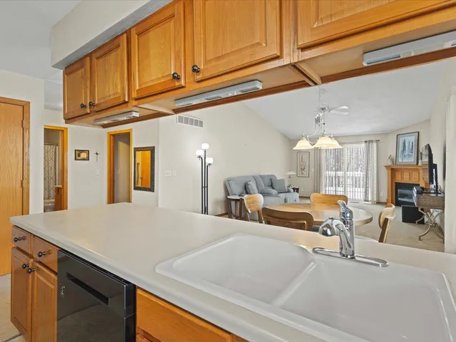 a living room with large couches a dining table and chairs with wooden floor