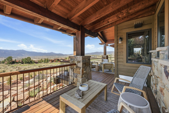 7885 North Rabbitbrush Court, Unit 13 Park City, UT 84098 - Photo 70 of 88 Expansive outdoor decking featuring a wood-finish ceiling, stone columns, and metal railings
