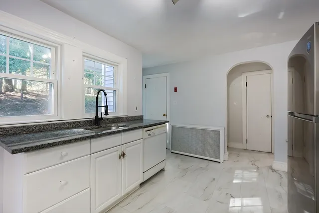 a bathroom with a granite countertop sink two mirror and a bathtub