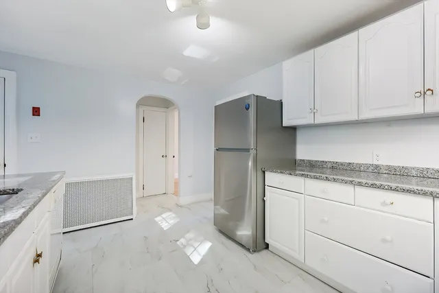 a kitchen with stainless steel appliances granite countertop a refrigerator and a stove
