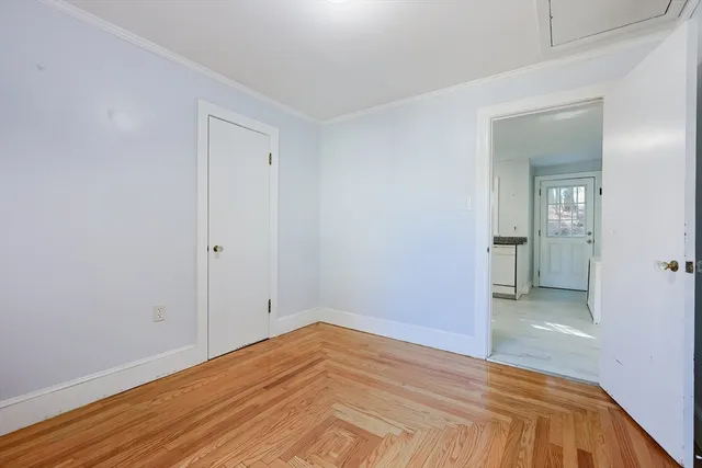 a view of empty room with wooden floor