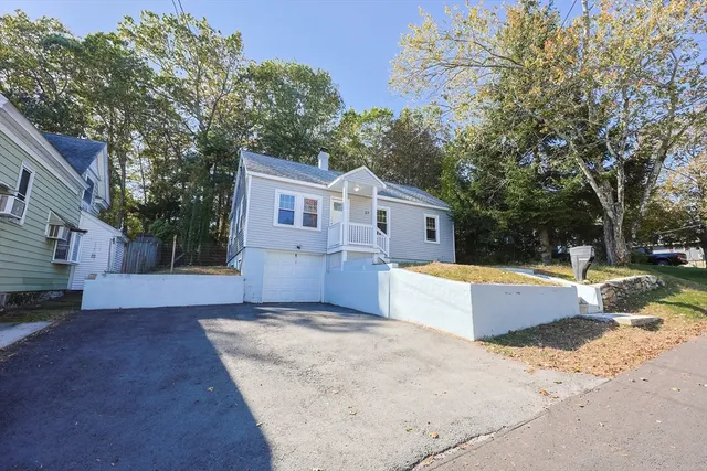 a view of a house with backyard and trees