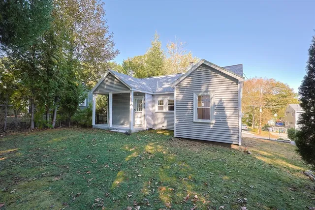 a view of a house with a yard and large tree
