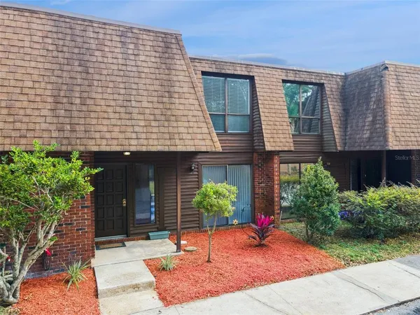 a brick building with potted plants in front of it