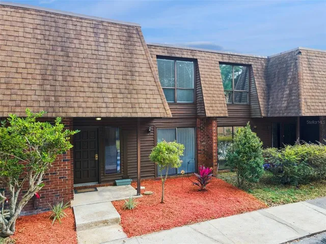 a brick building with potted plants in front of it