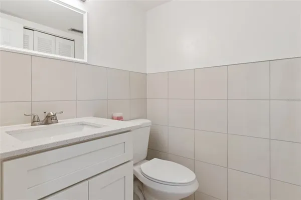 a bathroom with a toilet sink vanity and mirror