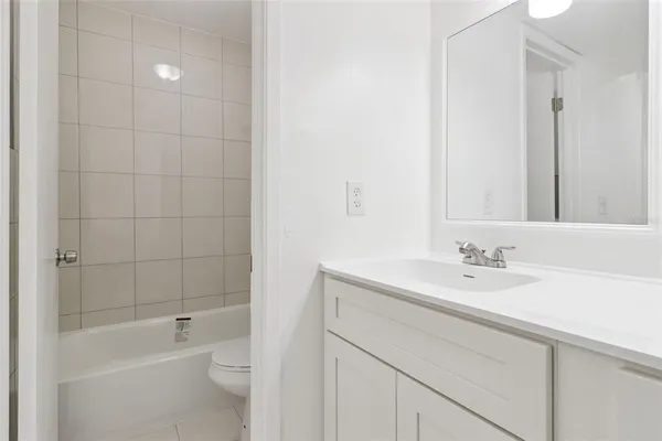 a bathroom with a bathtub shower sink vanity and toilet