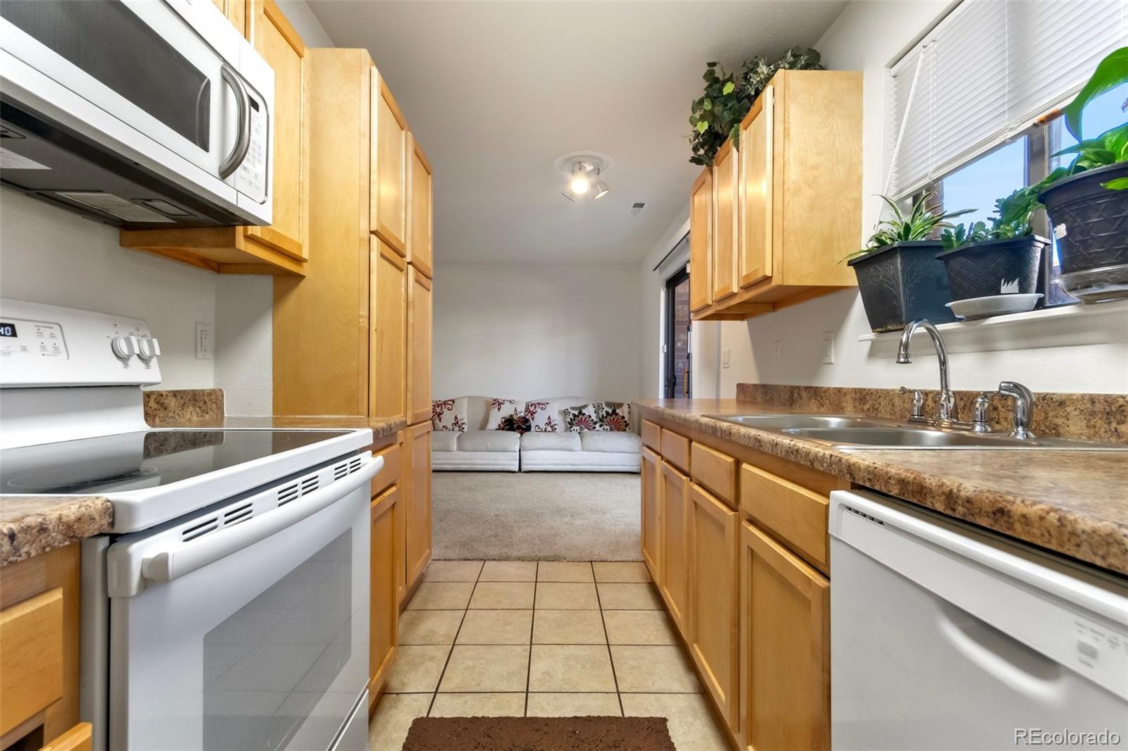 2265 South Buckley Road, Unit 102 Aurora, CO 80013 - Photo 16 of 28 a kitchen with stainless steel appliances granite countertop a sink and a stove