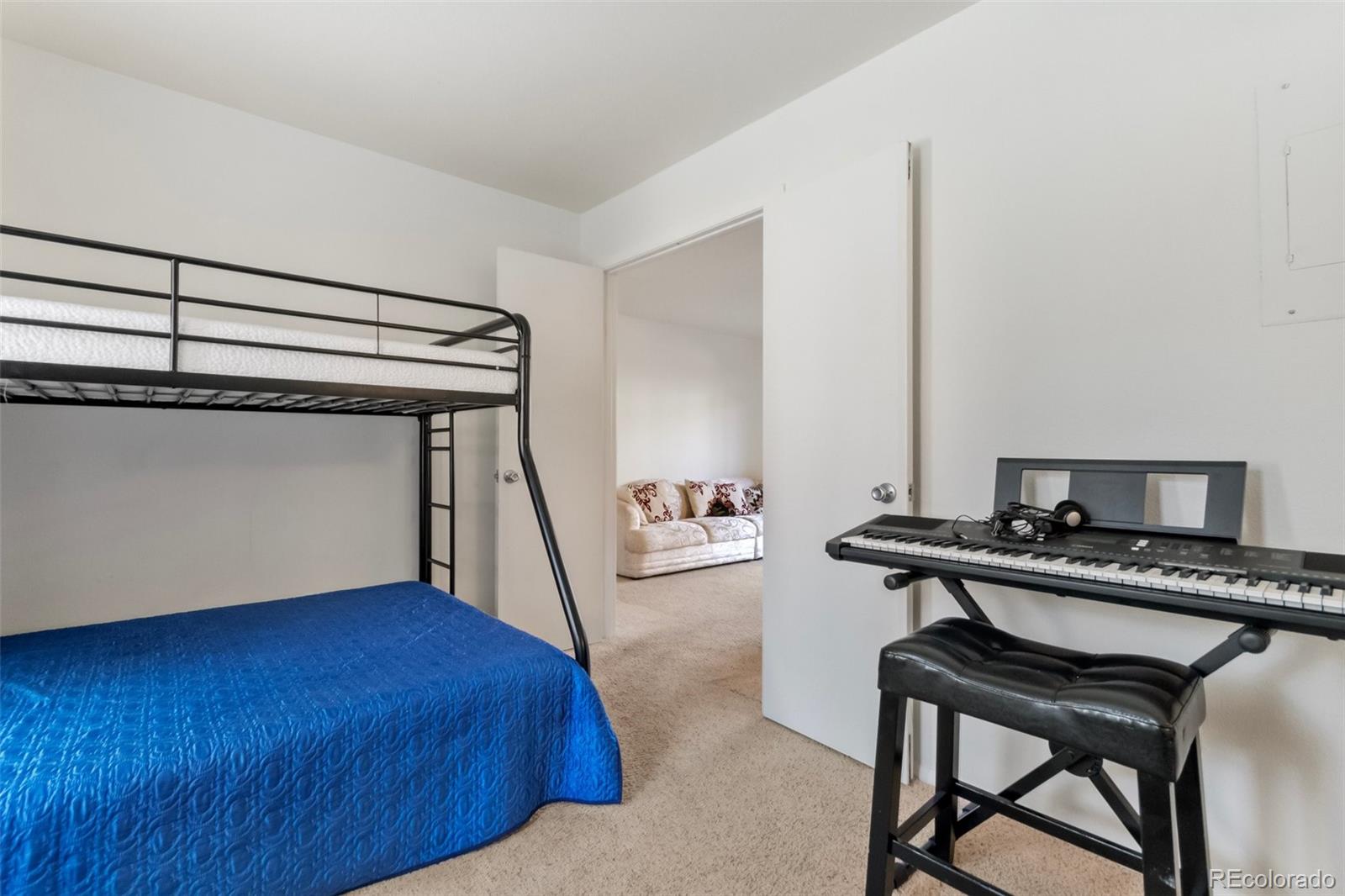 2265 South Buckley Road, Unit 102 Aurora, CO 80013 - Photo 21 of 28 a bedroom with a bed and a desk