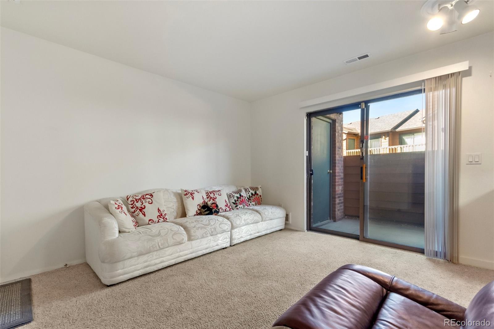 2265 South Buckley Road, Unit 102 Aurora, CO 80013 - Photo 7 of 28 a living room with furniture and a floor to ceiling window