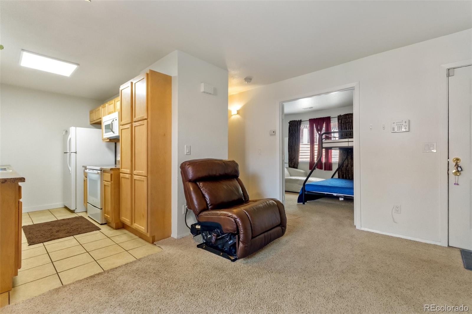 2265 South Buckley Road, Unit 102 Aurora, CO 80013 - Photo 9 of 28 a living room with furniture and a mirror