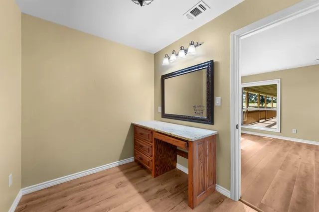a bathroom with a granite countertop toilet a sink and a mirror