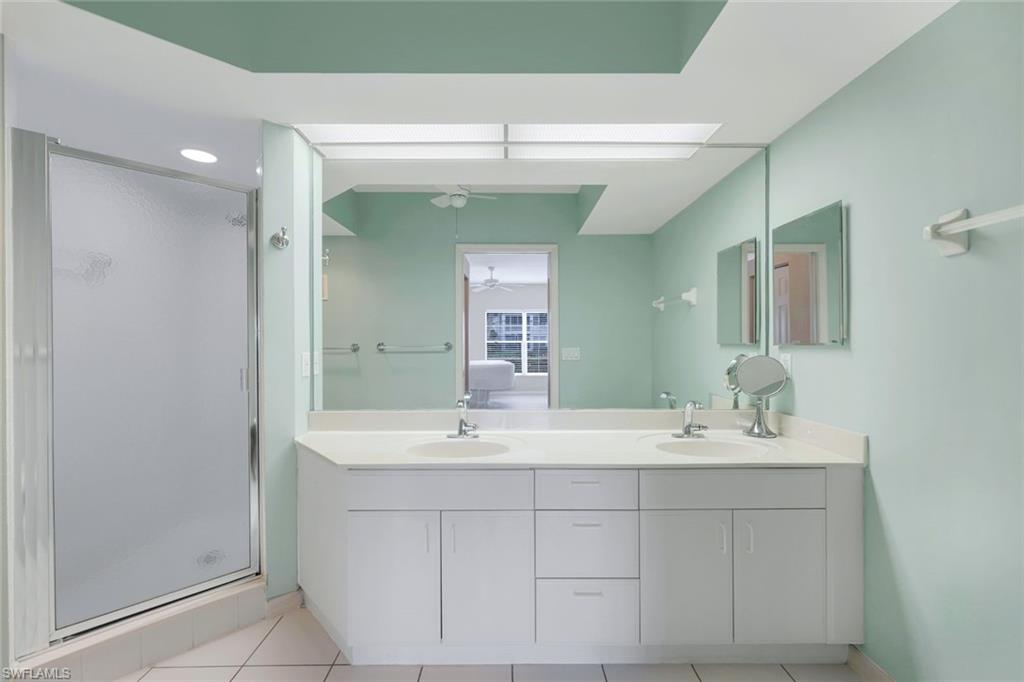 23711 Old Port Road, Unit 101 Estero, FL 34135 - Photo 18 of 30 Bathroom featuring tile patterned flooring, vanity, ceiling fan, and a shower with shower door