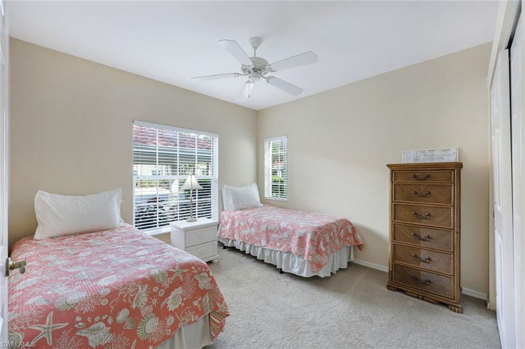 23711 Old Port Road, Unit 101 Estero, FL 34135 - Photo 19 of 30 Bedroom featuring ceiling fan, multiple windows, a closet, and light colored carpet