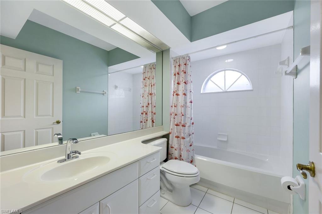 23711 Old Port Road, Unit 101 Estero, FL 34135 - Photo 20 of 30 Full bathroom featuring toilet, vanity, tile patterned floors, and shower / tub combo with curtain