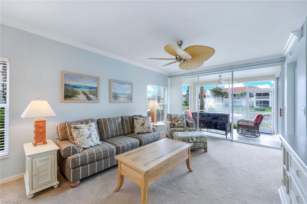 23711 Old Port Road, Unit 101 Estero, FL 34135 - Photo 6 of 30 Living room featuring a wealth of natural light, light carpet, ceiling fan, and crown molding