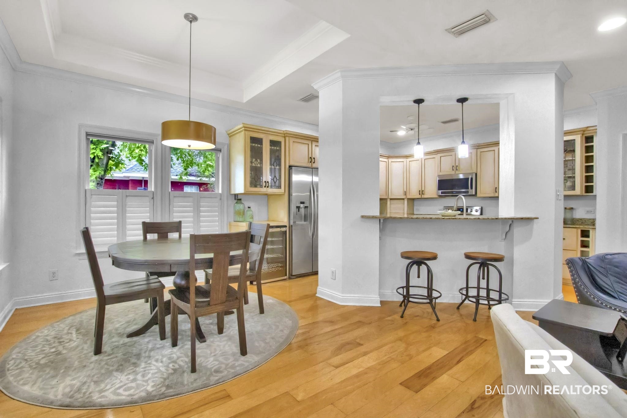 9002 Parliament Circle Daphne, AL 36526 - Photo 21 of 73 Dining space featuring light wood flooring, ornamental molding, and a tray ceiling