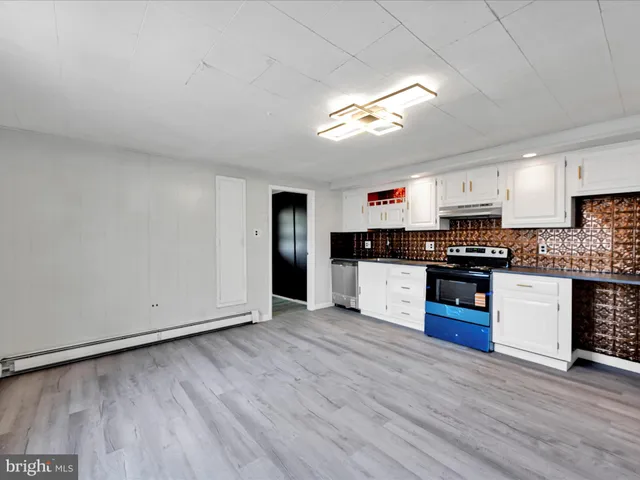 a large kitchen with stainless steel appliances granite countertop a stove and a refrigerator