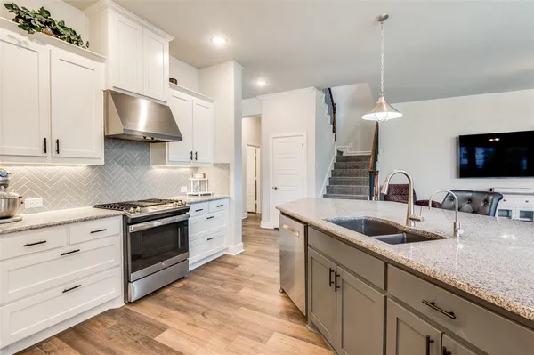 a kitchen with granite countertop a sink stainless steel appliances and cabinets