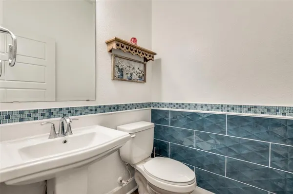 a bathroom with a sink a toilet and a mirror