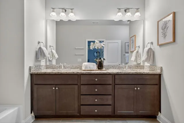a bathroom with a granite countertop sink a mirror and a vanity