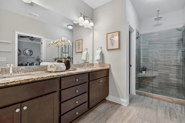 a bathroom with a granite countertop sink mirror and shower