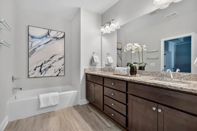 a bathroom with a bathtub sink and mirror