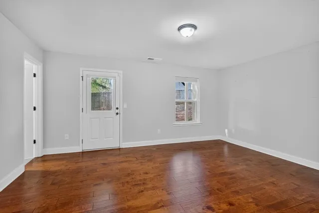 wooden floor in an empty room with a window