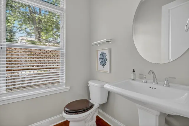 a bathroom with a sink a toilet and a mirror