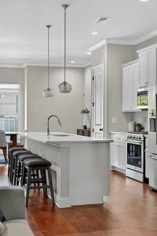 a kitchen with stainless steel appliances granite countertop a stove a sink a dining table and chairs