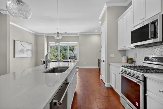 a kitchen with stainless steel appliances a stove a sink and a microwave