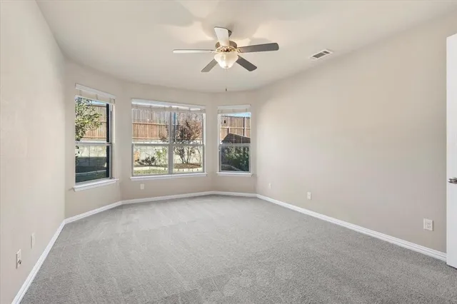 a view of an empty room and a ceiling fan