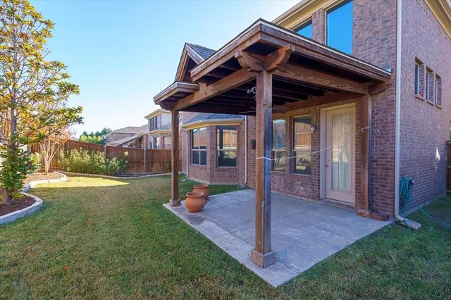 a view of a house with a yard potted plants and a large tree