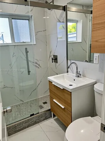 a bathroom with a sink a toilet and mirror